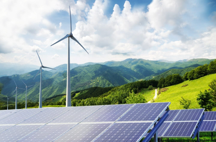 Wind turbines and solar panels on a green hillside